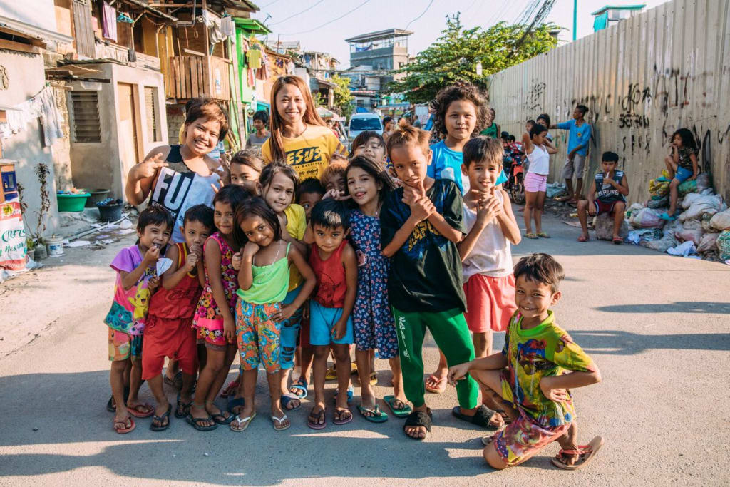 A group of children stand in a group and smile